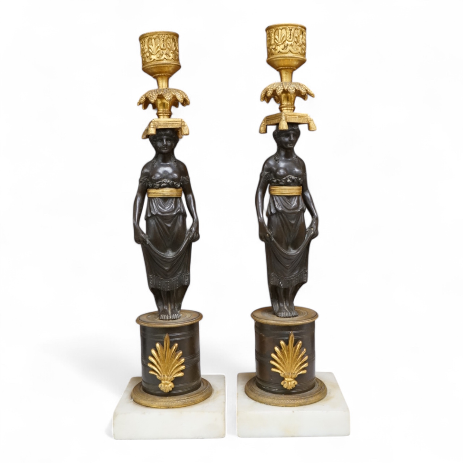 A pair of Regency bronze and gilt candlesticks in the form of standing classical figures mounted on marble bases, 31.5cm high.